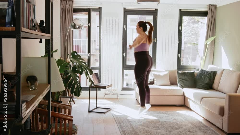 Full figured female person jumping and warming up while making her morning exercises Full figured female person jumping and warming up while making her morning exercises