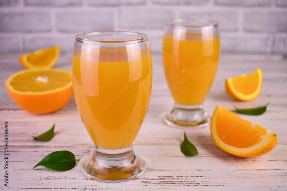 Orange juice in glasses on a white wooden background.	