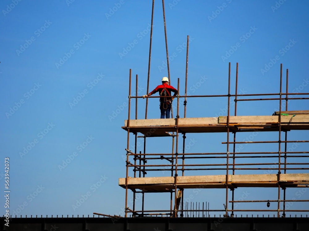 Unrecognizable construction worker on construction site scaffolding 