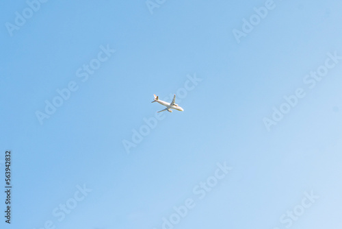 A white passenger plane on a blue sky background