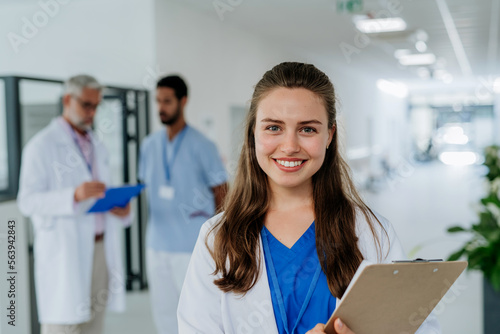 Canvas Print Portrait of young woman doctor at hospital corridor.