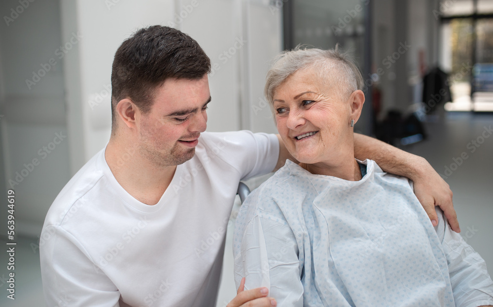 Young man with down syndome working in hospital as caregiver. Concpet of integration people with disability into society. Young man with down syndome working in hospital as caregiver. Concpet of integration people with disability into society.