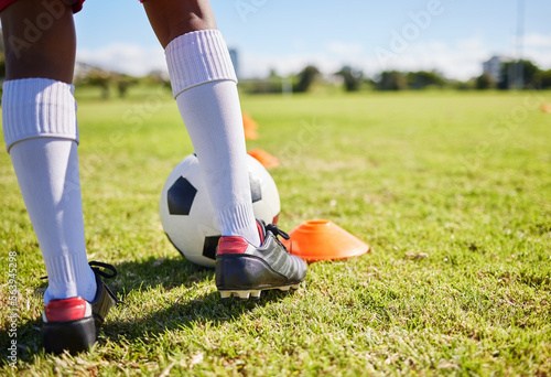 Closeup football kid, grass and training for fitness, sports and balance for control, speed and development. Young soccer player, fast dribbling or exercise feet on grass with cleats in low angle