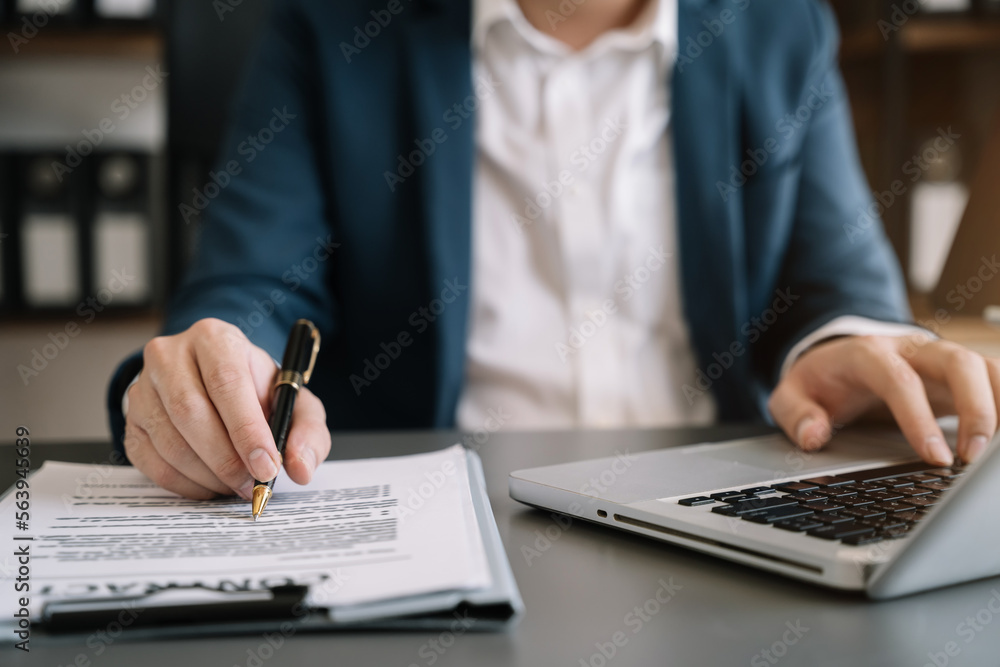 Fototapeta premium Male writes information businessman working on laptop computer writing business plan while sitting in office.