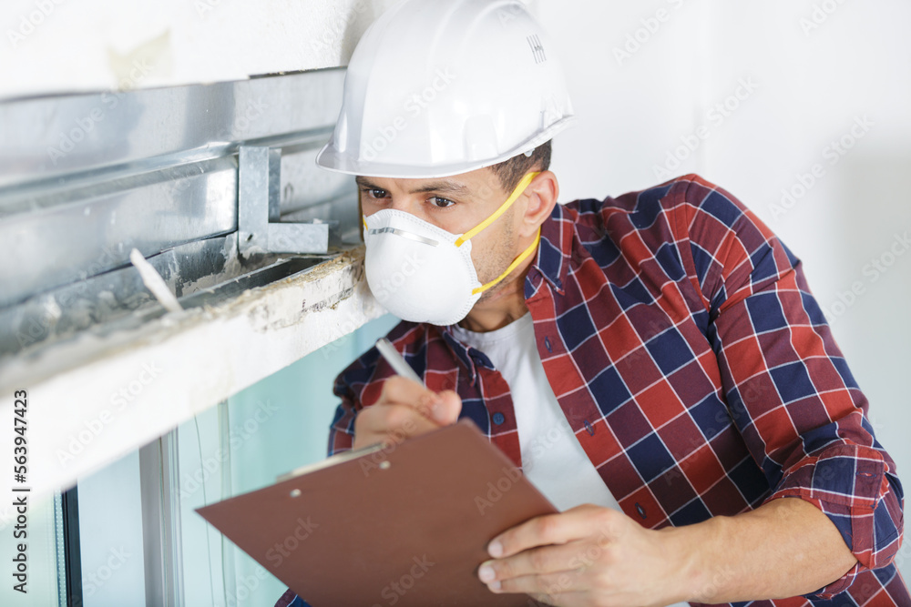 man inspecting a derelict property wearing a dust mask man inspecting a derelict property wearing a dust mask