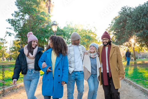 Cheerful group of students walking outdoors in the park of the campus University college having fun together. Erasmus bridge multiracial colleagues friendship. High quality photo