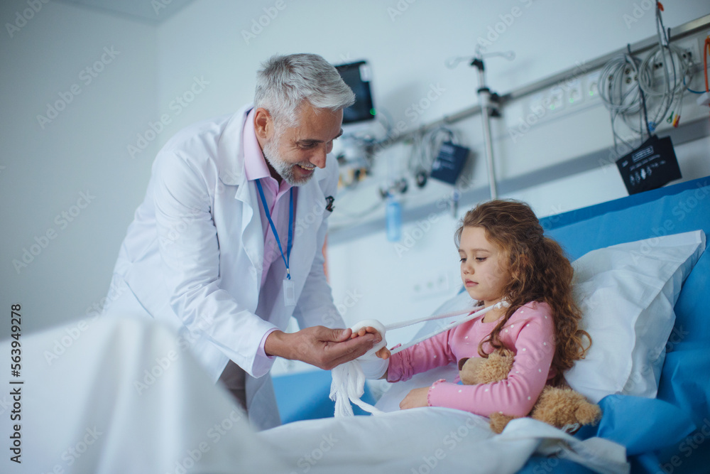 Doctor examining little girl with broken arm. Doctor examining little girl with broken arm.