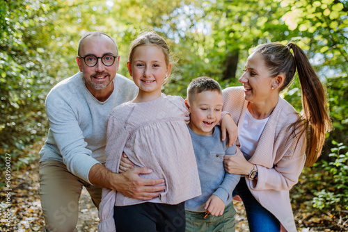 Portrait of happy family with kids in a forest. © Halfpoint