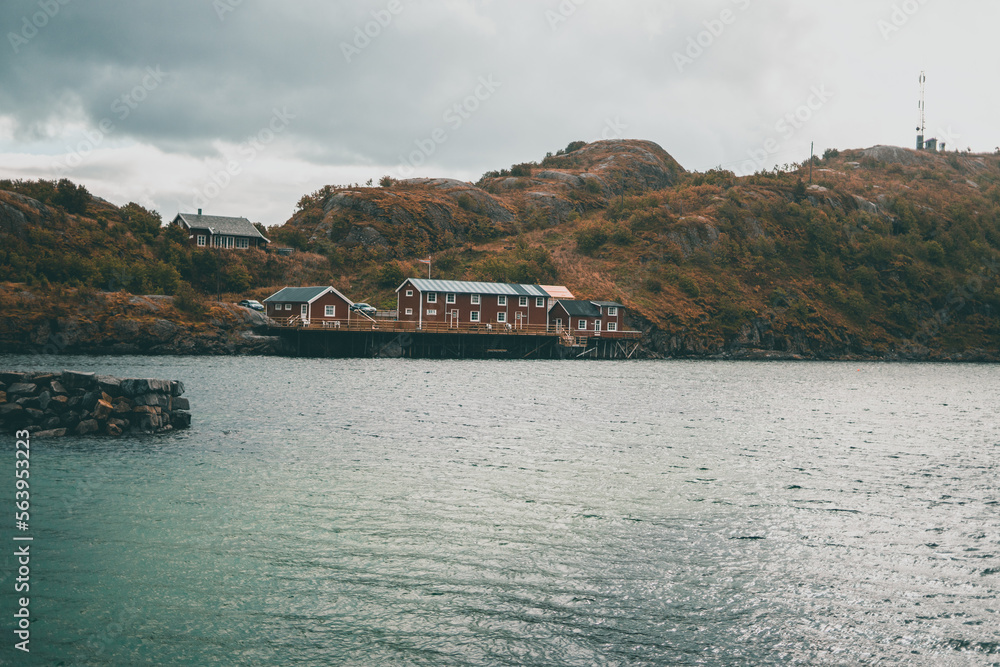 Fototapeta premium Typical red wooden houses at the harbor, on the Lofoten Islands in Norway - during an beautiful autumn day