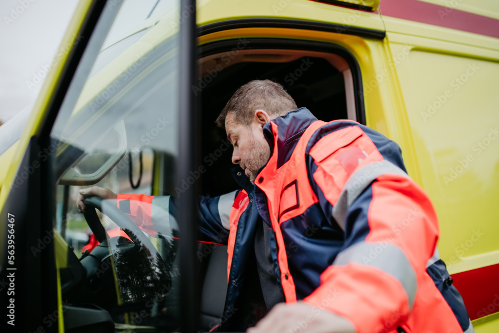 Rescuer getting in to ambulance car, preparing for rescue operation. Rescuer getting in to ambulance car, preparing for rescue operation.