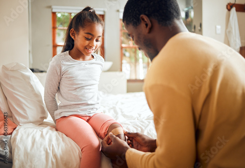 Black family, father and knee bandage for girl after accident or injury. First aid, healthcare and man apply bandaid or plaster on leg of hurt or injured child for wellness and recovery in bedroom.