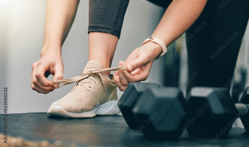 Fitness, hands or woman tie shoes lace before start of dumbbell exercise, gym training or sports workout. Health, wellness and legs of girl, athlete or person prepare for cardio performance challenge