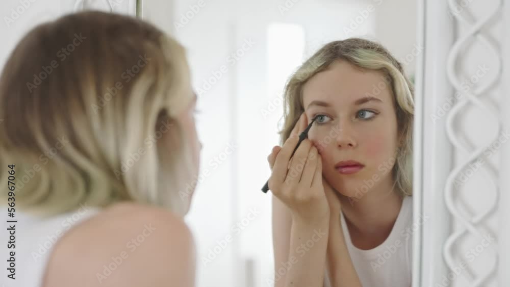 Teenage girl doing makeup with black eyeliner. Teenage girl doing makeup with black eyeliner.