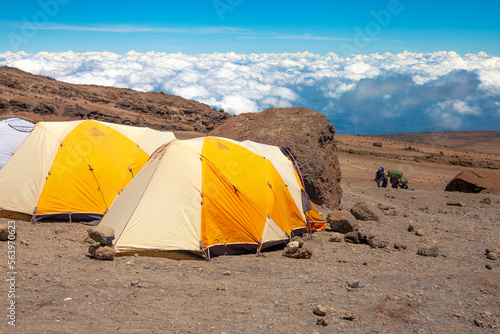 Yellow tents in the base camp above the clouds. 