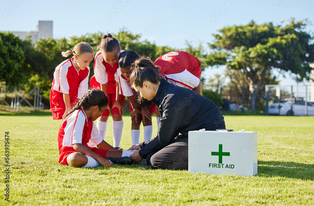 Sports, first aid and children soccer team with an injury after a game in a huddle helping a girl athlete. Fitness, training and kid with a sore, pain or muscle sprain on an outdoor football field. - obrazy, fototapety, plakaty 