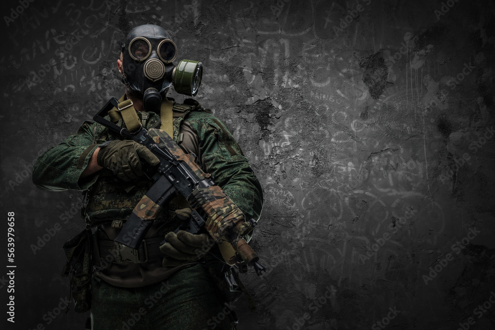 Shot of contemporary soldier with gas mask holding rifle against dark background. Shot of contemporary soldier with gas mask holding rifle against dark background.