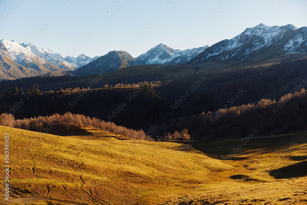 Obraz premium Autumn landscape of the nature of the mountains on a trip with snow-capped winter peaks in the background, off roads