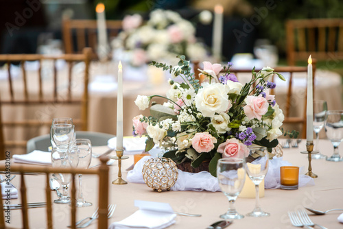 Beautiful table setting with tableware, flowers, candles, accessories and rose centerpiece for a party, wedding reception, gala banquet or other holiday event. photo