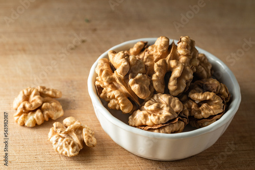 bowl of Shelled walnut wooden table healthy food Close-up kernels and whole walnuts on rustic old.