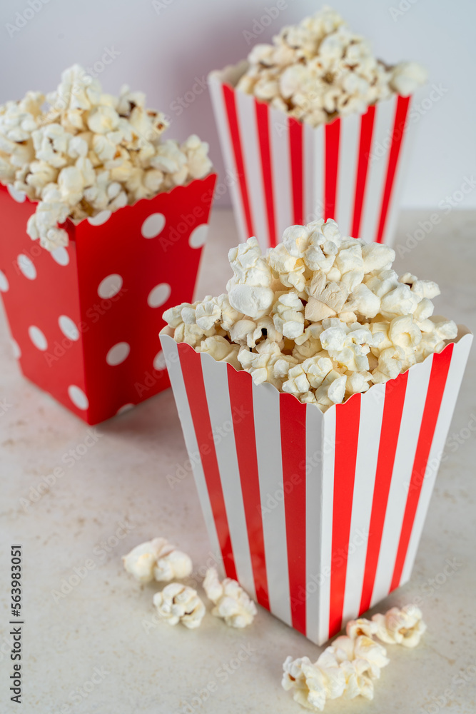 Three bags of popcorn in red and white on a white background, front view, closeup Three bags of popcorn in red and white on a white background, front view, closeup