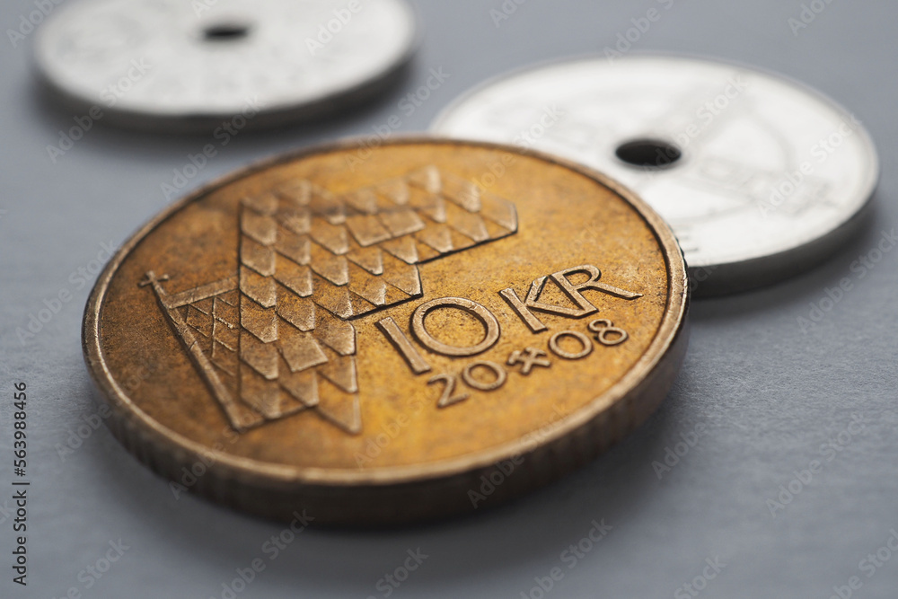 Norwegian coins lie on gray surface. 10 Norges kroner coin close up. National currency of Norway. Money illustration for news about economy or finance. Banking and credit. Wages and taxes. Macro Norwegian coins lie on gray surface. 10 Norges kroner coin close up. National currency of Norway. Money illustration for news about economy or finance. Banking and credit. Wages and taxes. Macro