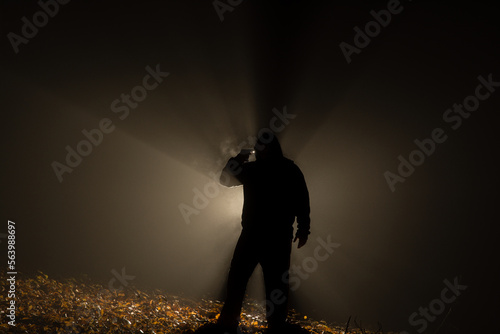 Suicide armed silhoulette man in dark forest at backlight