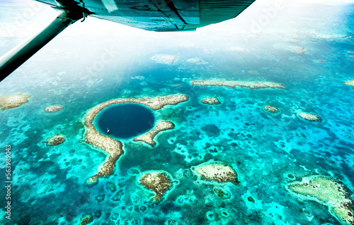 Aerial panoramic view of The Great Blue Hole - Detail of Belize coral reef from airplane excursion - Wanderlust and travel concept with nature wonders on azure vivid filter photo