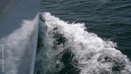The bow of the white yacht cuts the waves. Slow motion photo