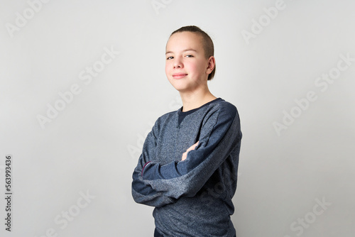 Portrait of teenage boy with crossing hands on white background