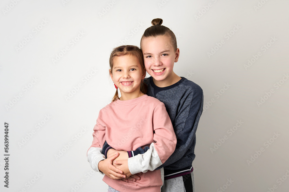 Boy and girl hugging each other on white background