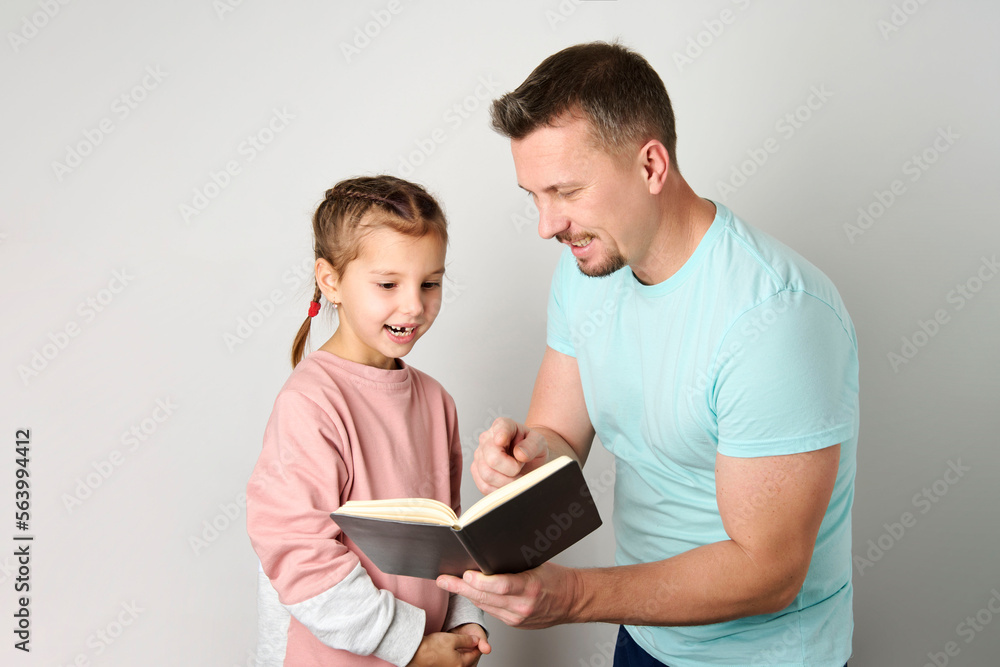 Young father and daughter reading book close-up. Young father and daughter reading book close-up.