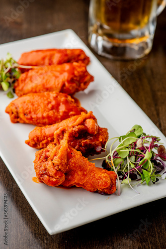 
Chicken wings. Buffalo chicken wings. American cuisine of chicken wings deep-fried, dipped in buffalo sauce made of vinegar,  cayenne hot sauce and butter. Served with celery, carrots, blue cheese.