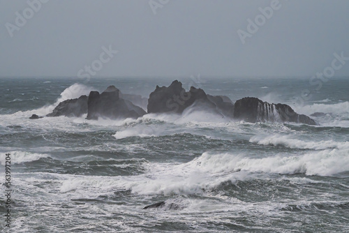 Waves crash on rocks in ocean during storm.