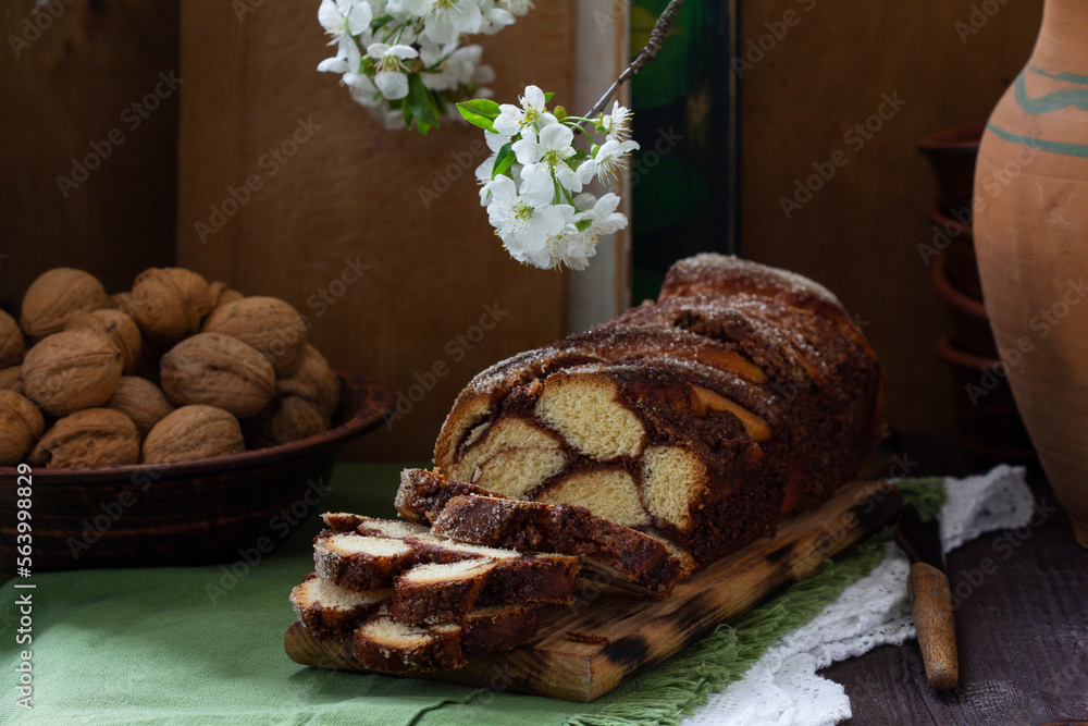 Traditional Easter bread with chocolate and nut filling on a wooden background.