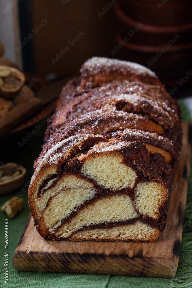Traditional Easter bread with chocolate and nut filling on a wooden background.