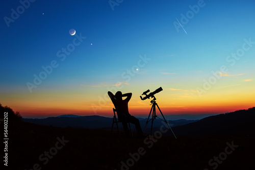 Fototapete Man with astronomy telescope looking at the night sky, stars, planets, Moon and shooting stars