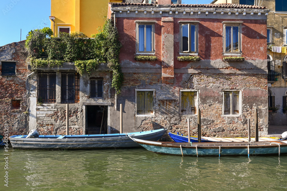 Boats moored in front of an old palace on Rio della Sensa canal in the sestiere of Cannaregio in summer, Venice, Veneto, Italy