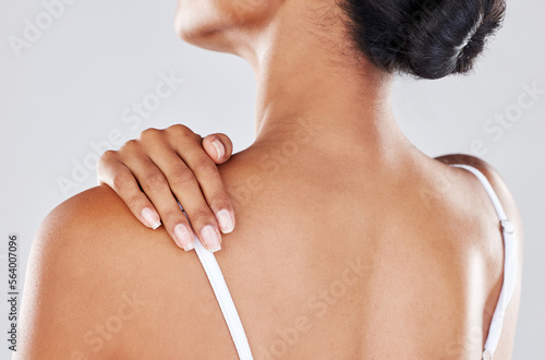 Shoulder pain, injury and woman hand on her back due to hurt, inflammation or muscle strain isolated in a studio gray background. Stress, spa and massage by model for body health or wellness