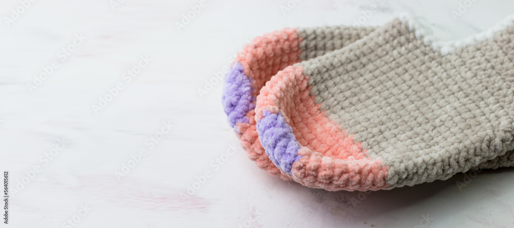 Fototapeta premium Warm knitted women's slippers. A gift with care. Knitting, hobbies