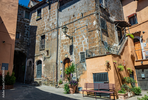 Fototapeta Naklejka Na Ścianę i Meble -  June 02, 2022 - Corchiano, Viterbo, Lazio - Small medieval village. The narrow streets of the small town with the old brick houses. The blue sky on a sunny day in summer.