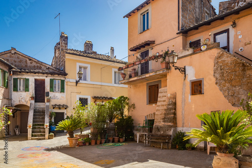 Fototapeta Naklejka Na Ścianę i Meble -  June 02, 2022 - Corchiano, Viterbo, Lazio - Small medieval village. The narrow streets of the small town with the old brick houses. The blue sky on a sunny day in summer.