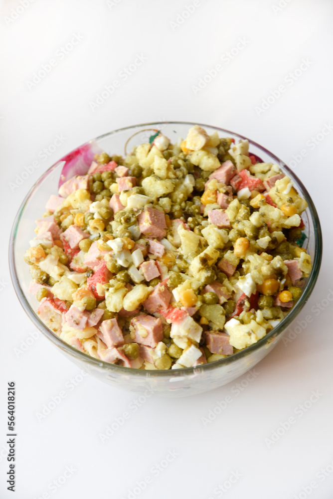 New Year's salad of meat vegetables and mayonnaise in a large plate. Delicious salad with corn and potatoes. New Year's salad of meat vegetables and mayonnaise in a large plate. Delicious salad with corn and potatoes.