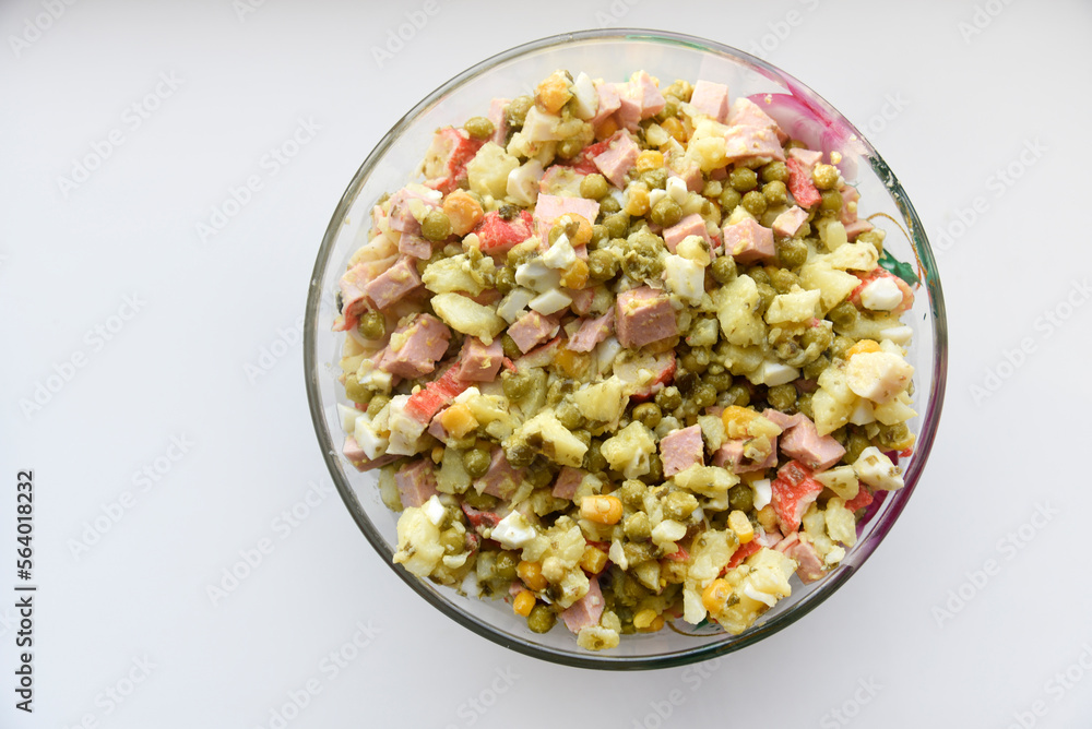 New Year's salad of meat vegetables and mayonnaise in a large plate. Delicious salad with corn and potatoes. New Year's salad of meat vegetables and mayonnaise in a large plate. Delicious salad with corn and potatoes.