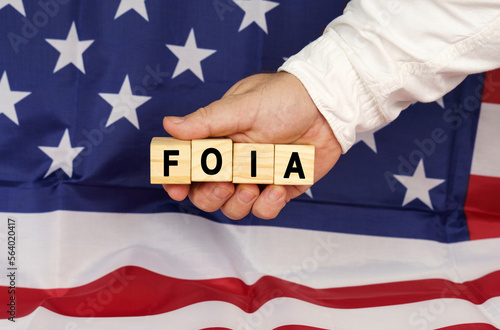 Against the background of the USA flag, a man's hand with cubes with the text - FOIA photo
