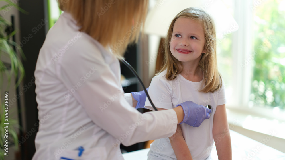 Fototapeta premium Young female patient smiles at doctor at medical examination.