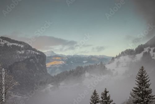 Looking down towards the Lauterbrunnen valley from Wengen area with low clouds and some haze in the air during winter time.