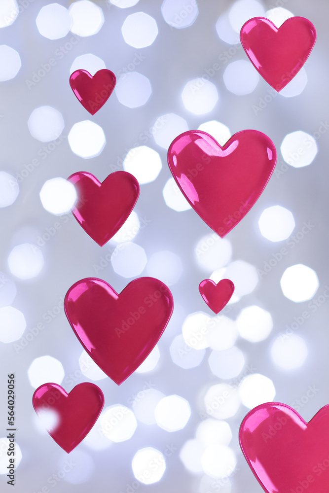 Festive Valentine’s Day background with red hearts floating between bokeh lights.