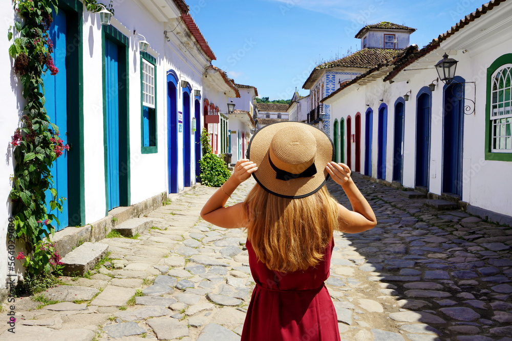 Tourism in Paraty, Brazil. Back view of beautiful fashion girl enjoying visiting historic town of Paraty, Rio de janeiro. Summer vacation in Brazil.