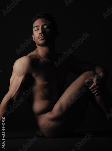 Nude, art and sensual with a model asian man in studio on a dark background for artistic body positivity. Skin, natural and artwork with a handsome young male posing naked on a black backdrop