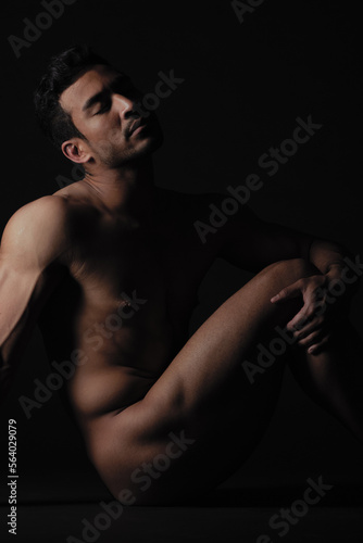 Nude, art and freedom with a model asian man in studio on a dark background for artistic body positivity. Skin, natural and artwork with a handsome young male posing naked on a black backdrop